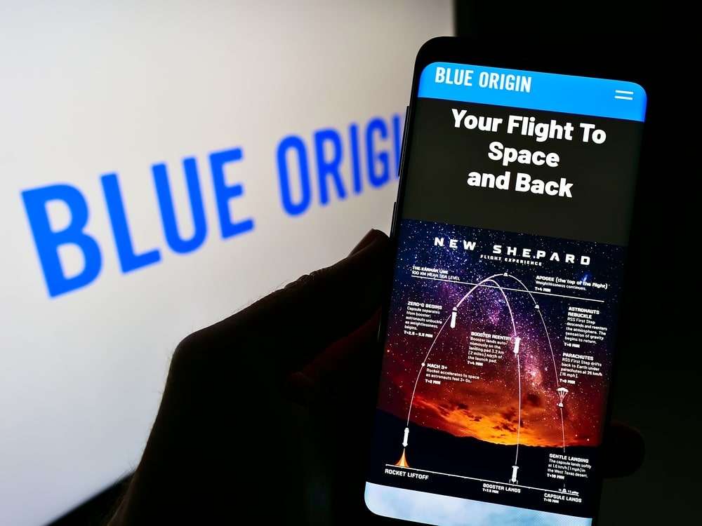 Person-holding-a-cell-phone-with-the-Blue-Origin-aerospace-company-web-page-d5e865307552a329a508289250ca504b.jpg